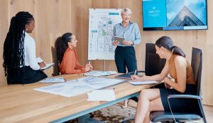 Équipe réunie autour d’un ordinateur pour planifier un projet après une session de formation.